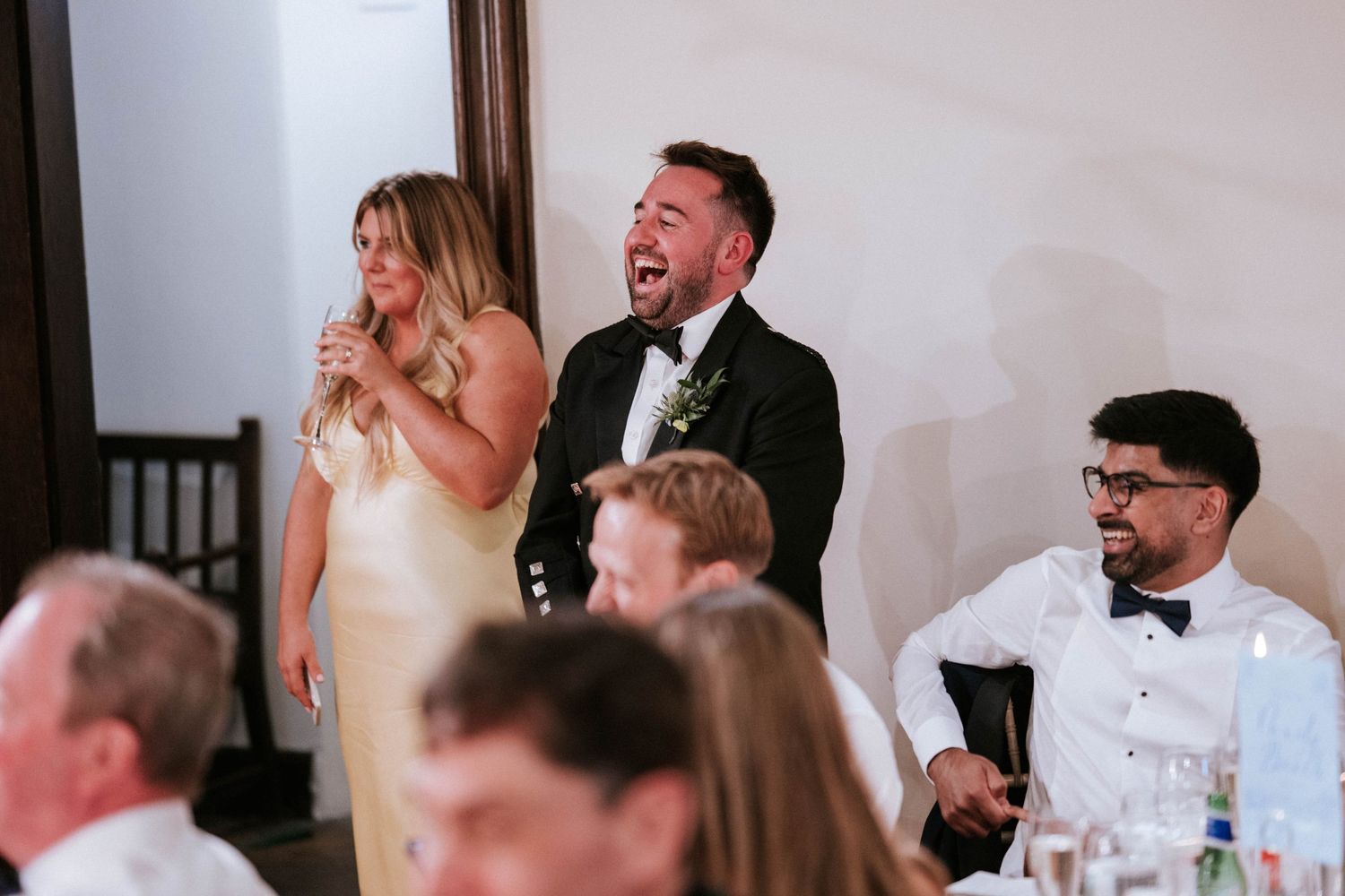 Wedding guests enjoying emotional speeches during an elegant indoor reception.