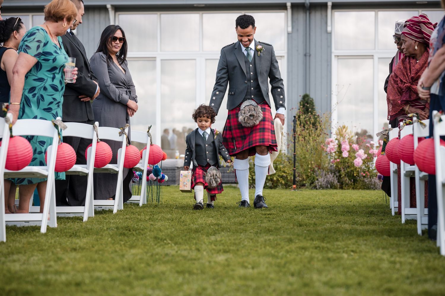 White chairs arranged in rows on green lawn for outdoor wedding ceremony.