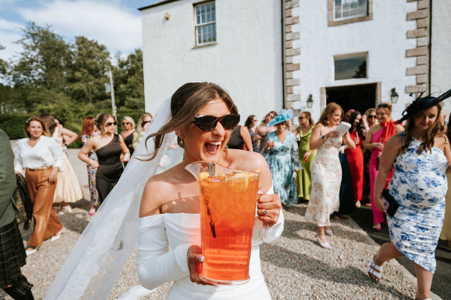 Aberdeen Wedding Photography. Wedding celebration with guests enjoying bright orange cocktails outdoors.