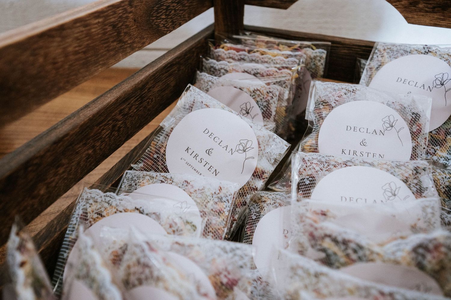 Wedding place cards and favors arranged on a dark wooden surface with decorative elements.