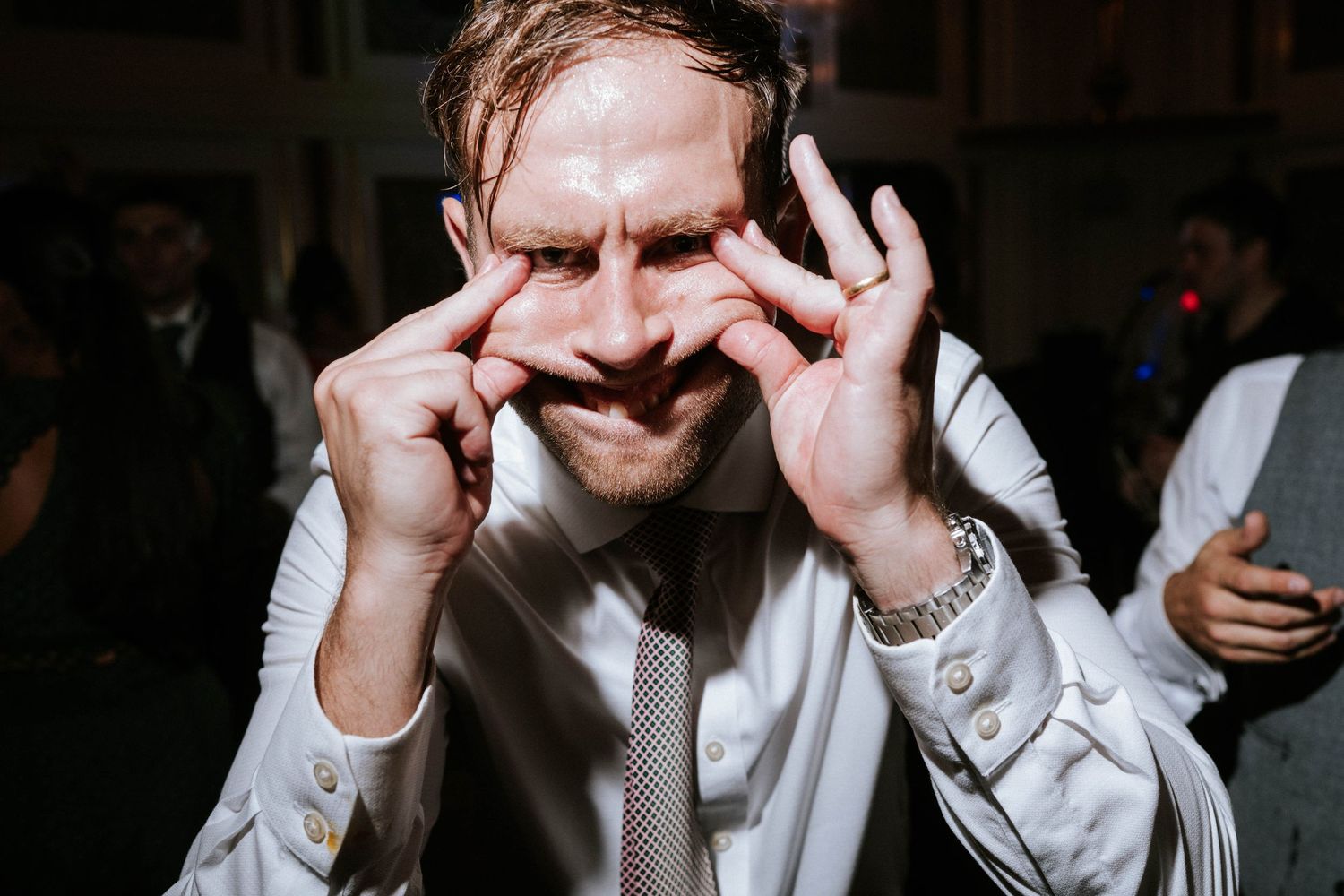 Dynamic party shots of wedding guests dancing and celebrating in dimmed lighting.