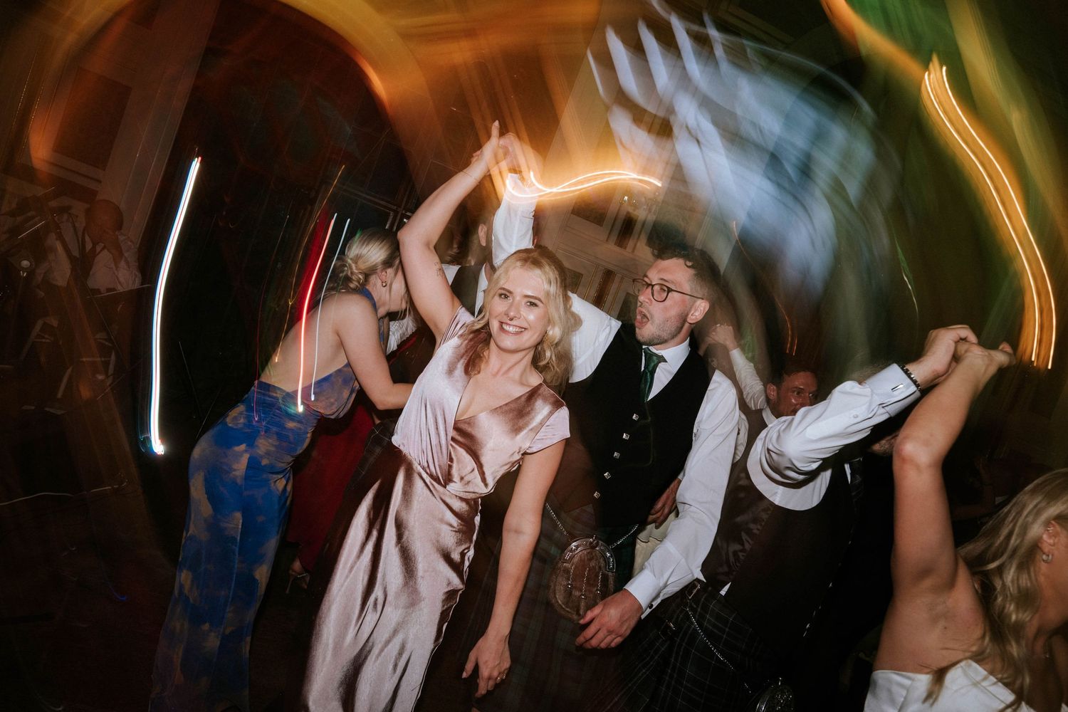 Candid reception party moments captured in atmospheric lighting.