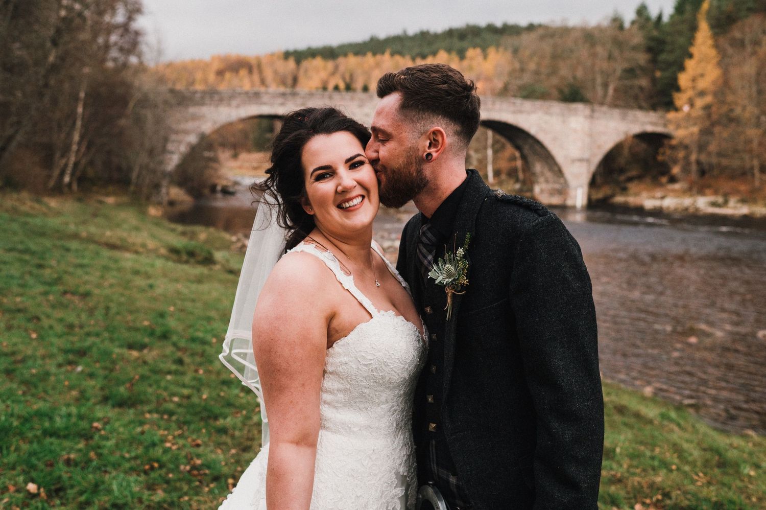 Bride and groom share laughter during their outdoor autumn wedding photoshoot.