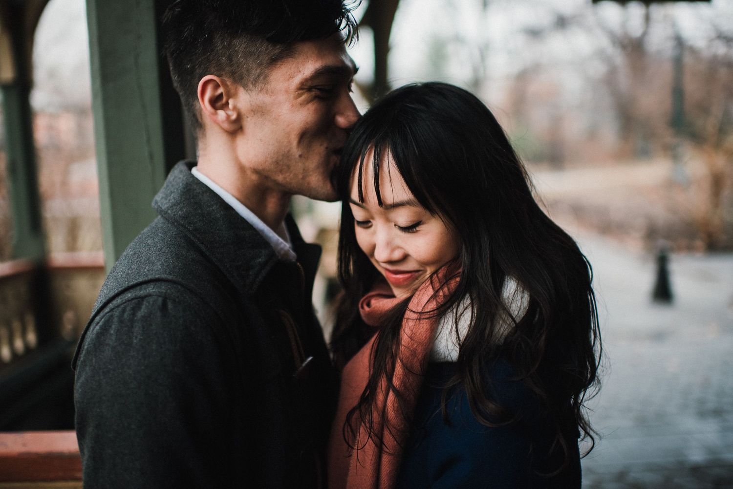 A couple shares a tender moment together on a rustic wooden porch.