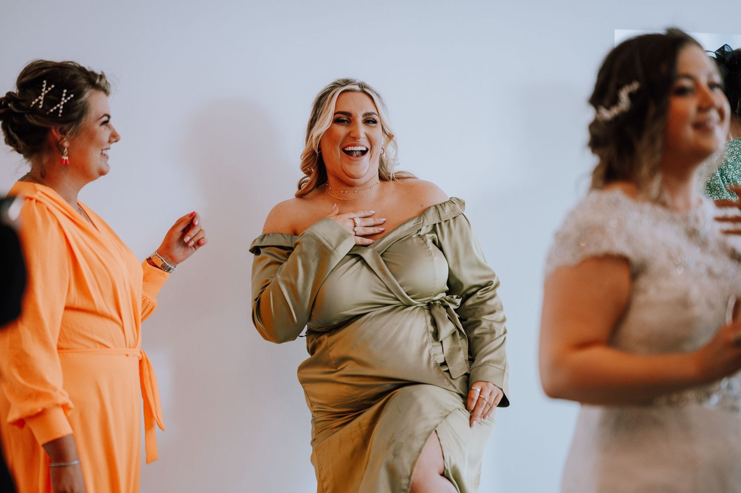 Wedding attendees in formal attire share an animated moment together.