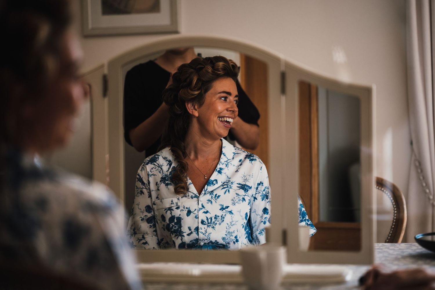 Getting ready scene with blue floral robe reflected in vanity mirror.