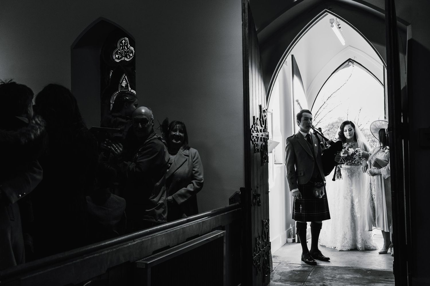 Black and white photo capturing a traditional church wedding ceremony entrance.