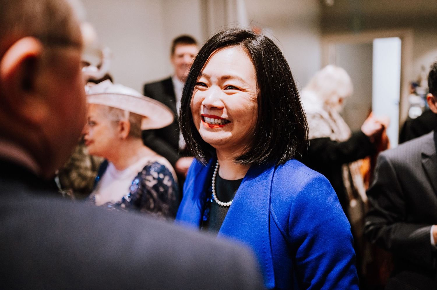 Reception guests share laughter and conversation during a joyful wedding celebration.