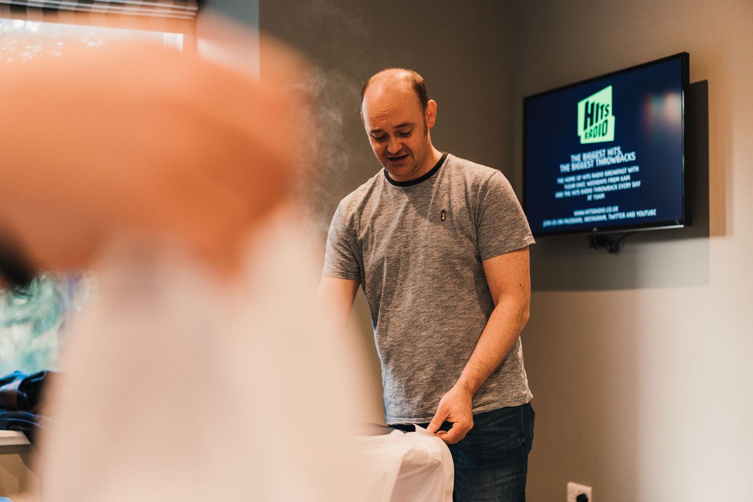Behind the scenes preparation moment at an event with a TV screen visible.