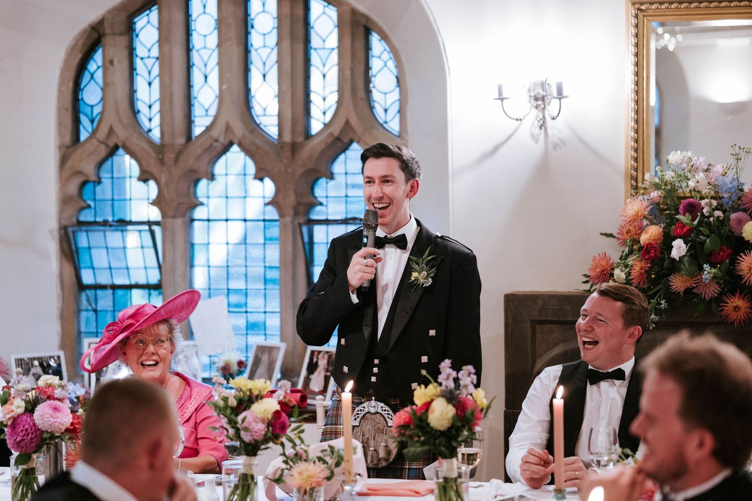 Wedding reception venue with gothic windows and romantic floral decorations.