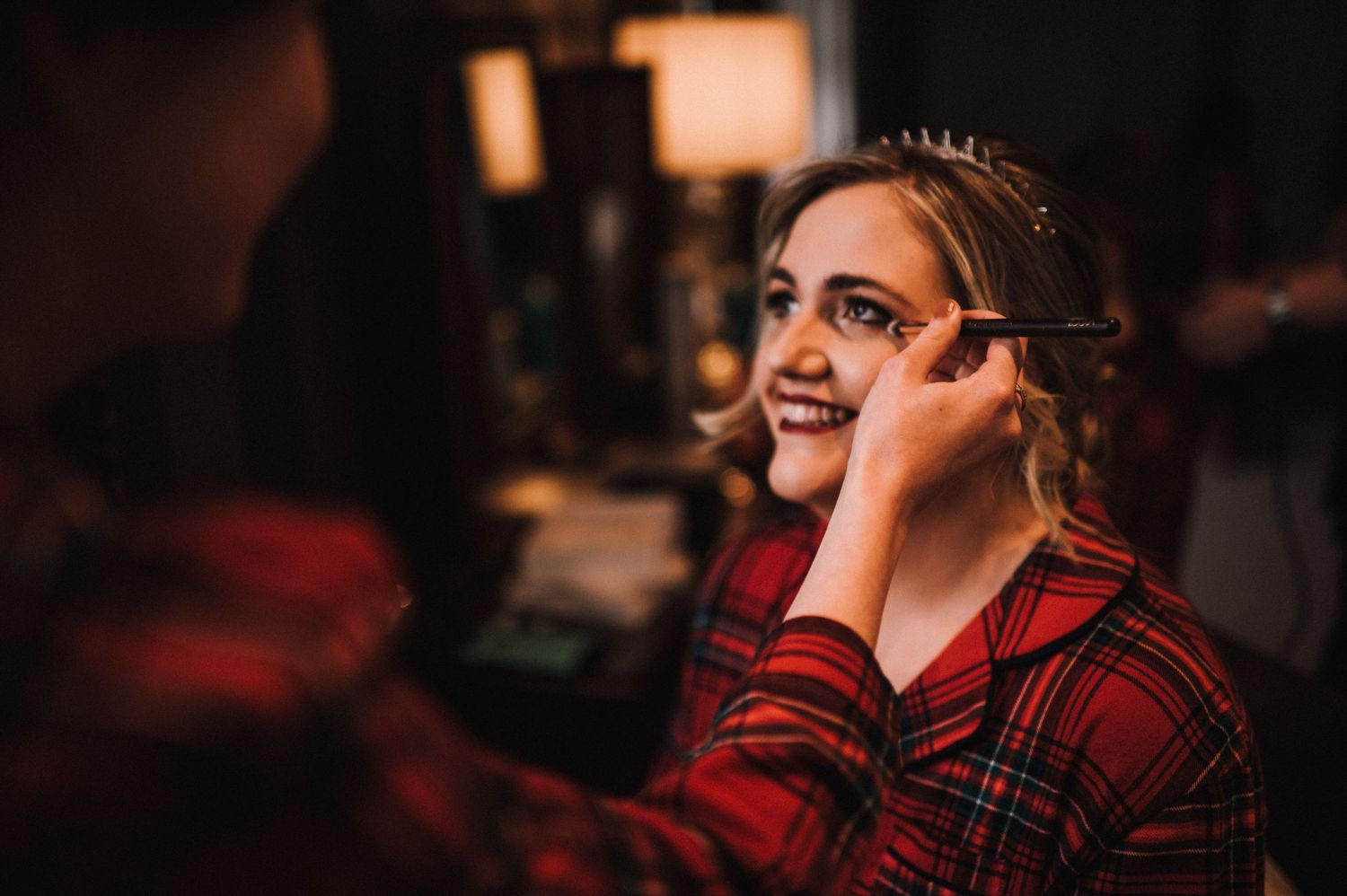 Candid moment captured during wedding preparations with soft lighting.