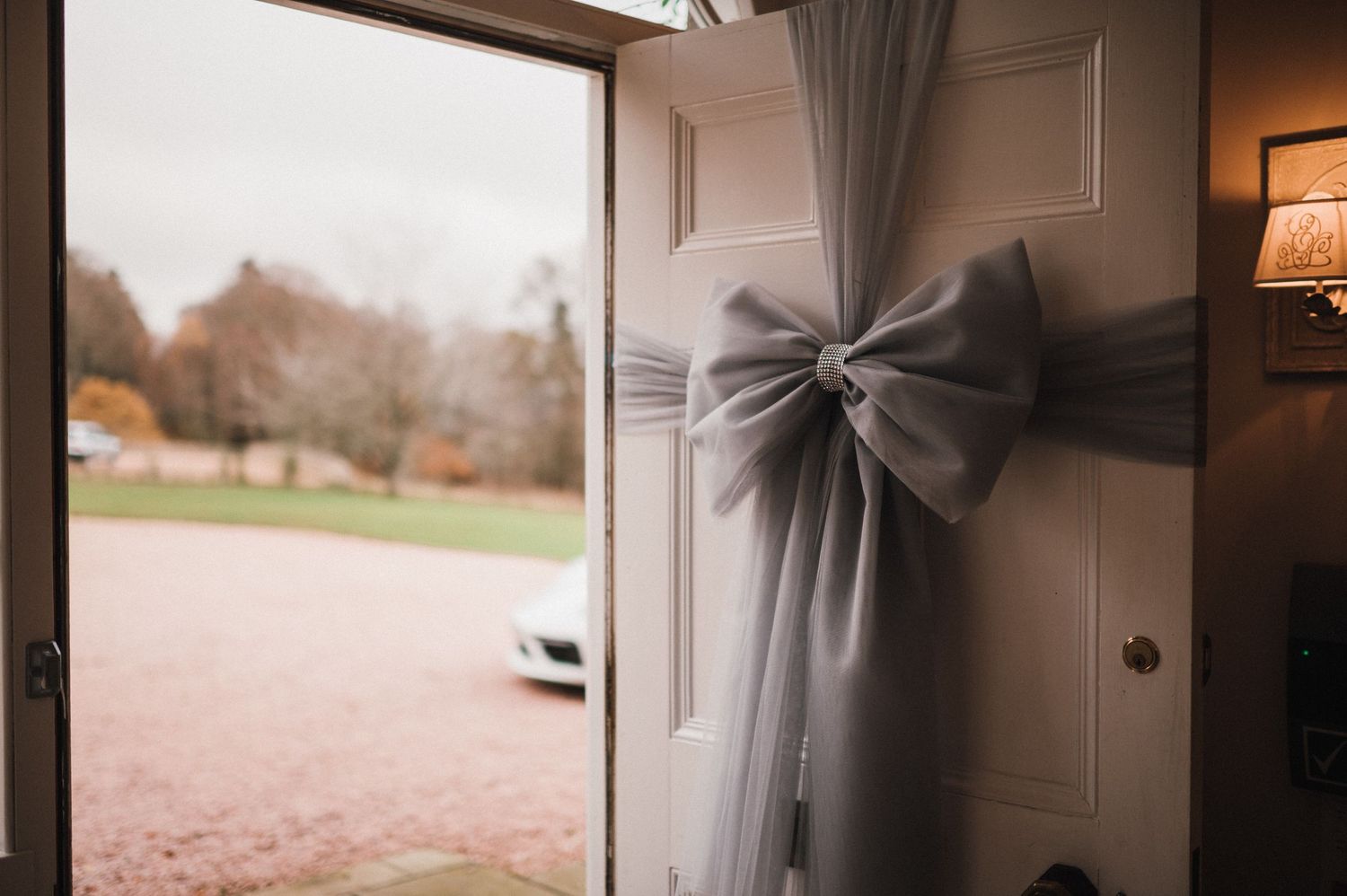 A white door decorated with an elegant grey bow detail.
