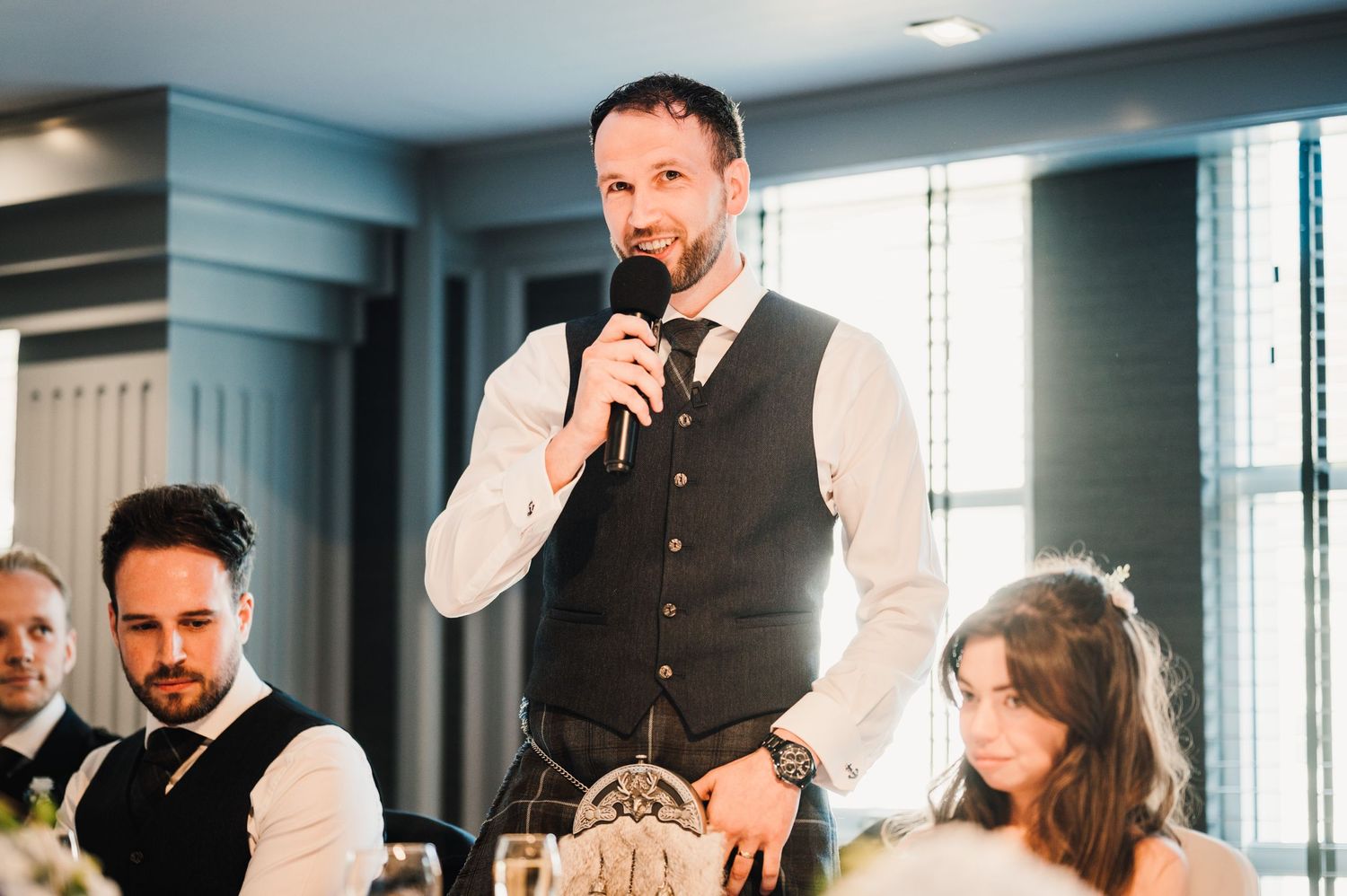 A guest delivers a speech during a wedding reception dinner.