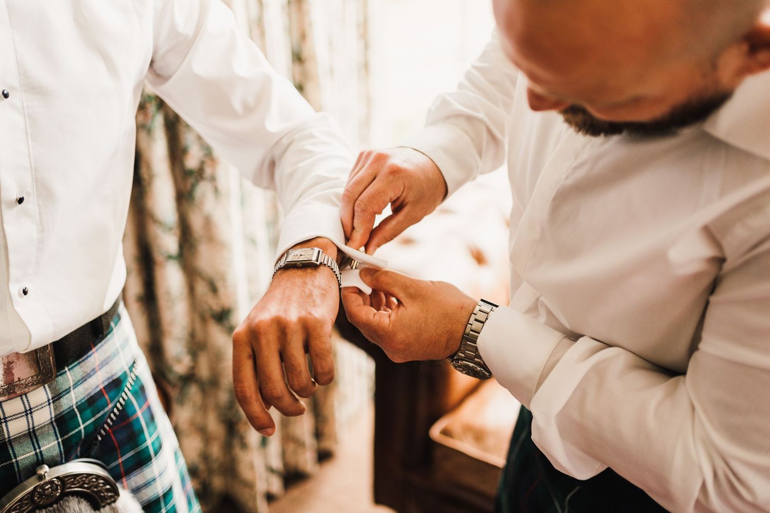 Close-up of hands adjusting formal wear accessories and cuffs.