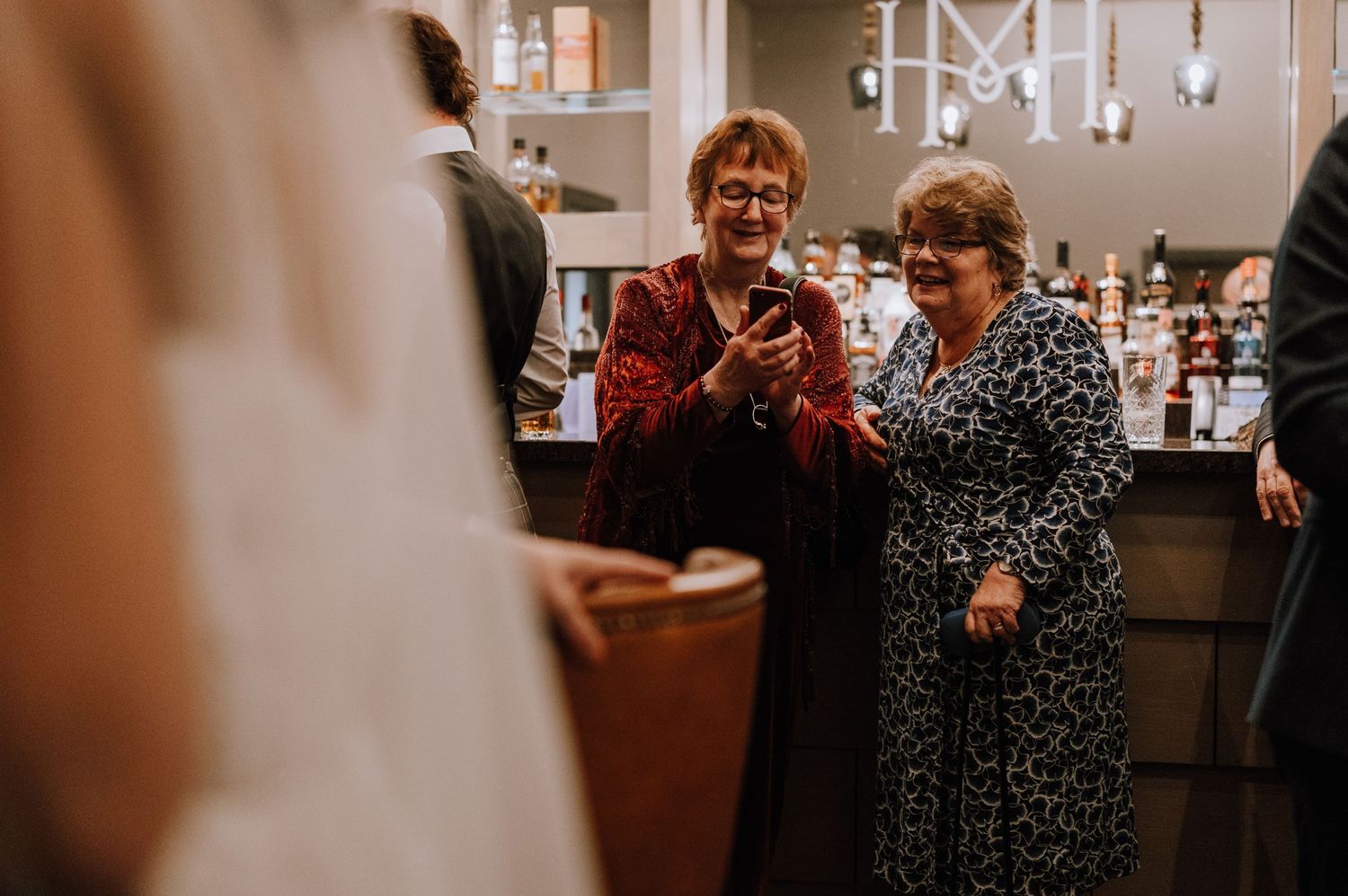 Two guests share a pleasant moment at a formal celebration near a bar area.