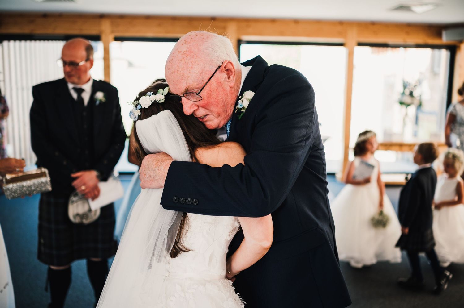 Emotional wedding moment captured as guests share heartfelt embraces during the ceremony.