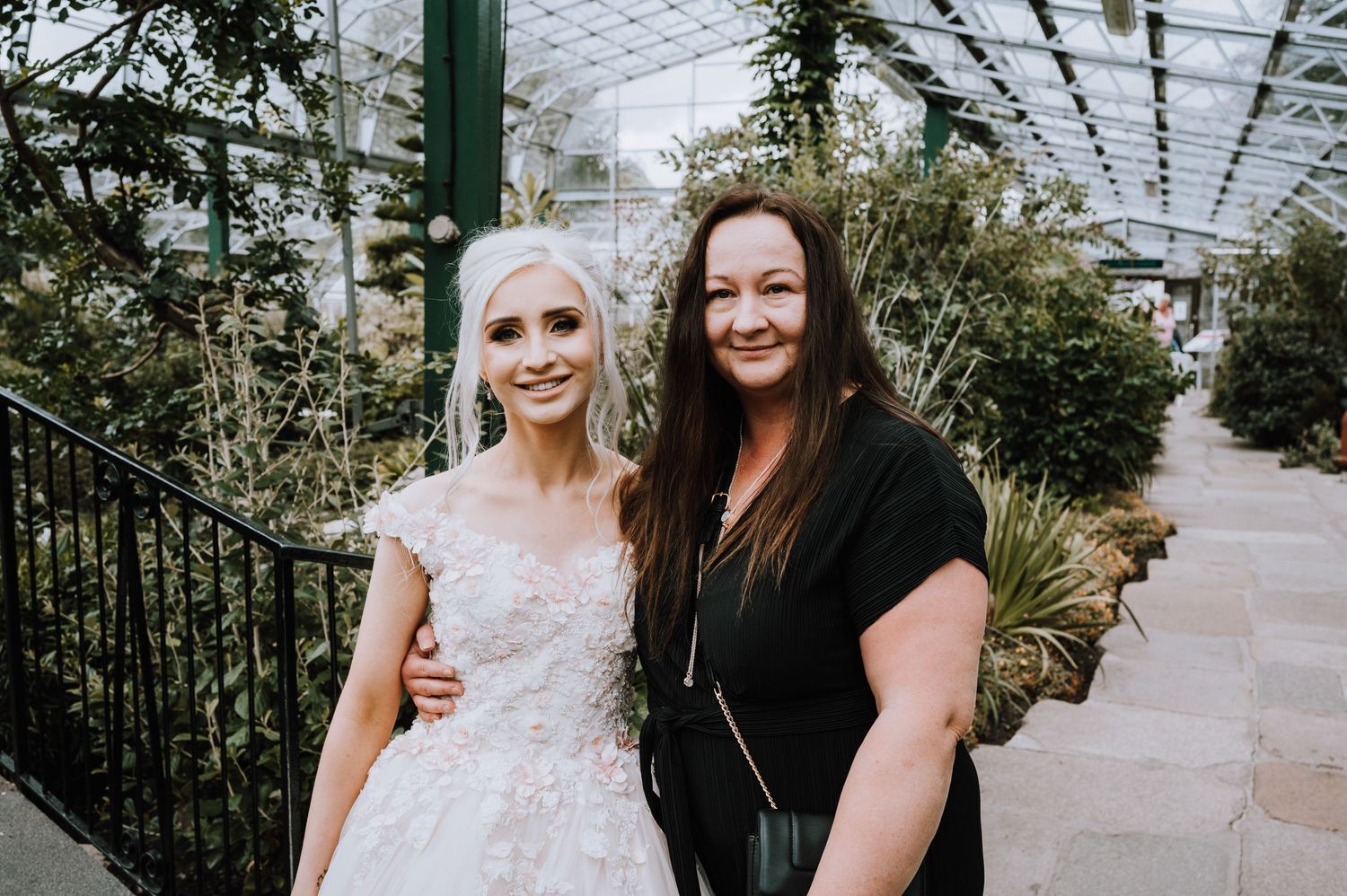 Wedding celebration moment captured in botanical garden conservatory setting.