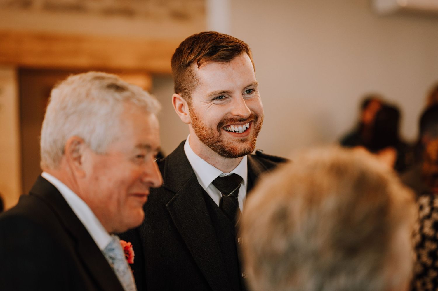 Guests sharing smiles and conversation during wedding reception.