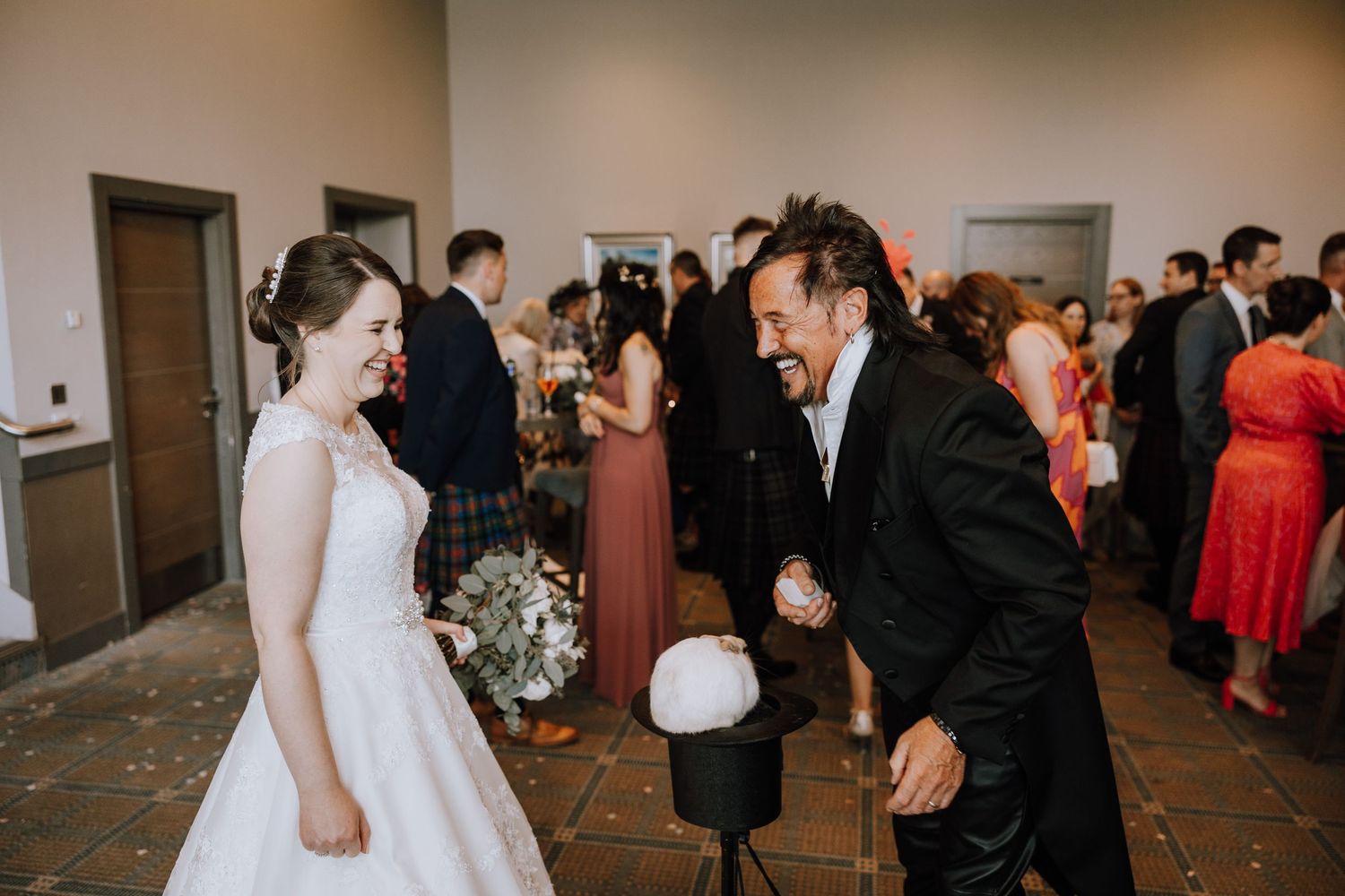 Wedding reception guests dancing and celebrating in an indoor venue.