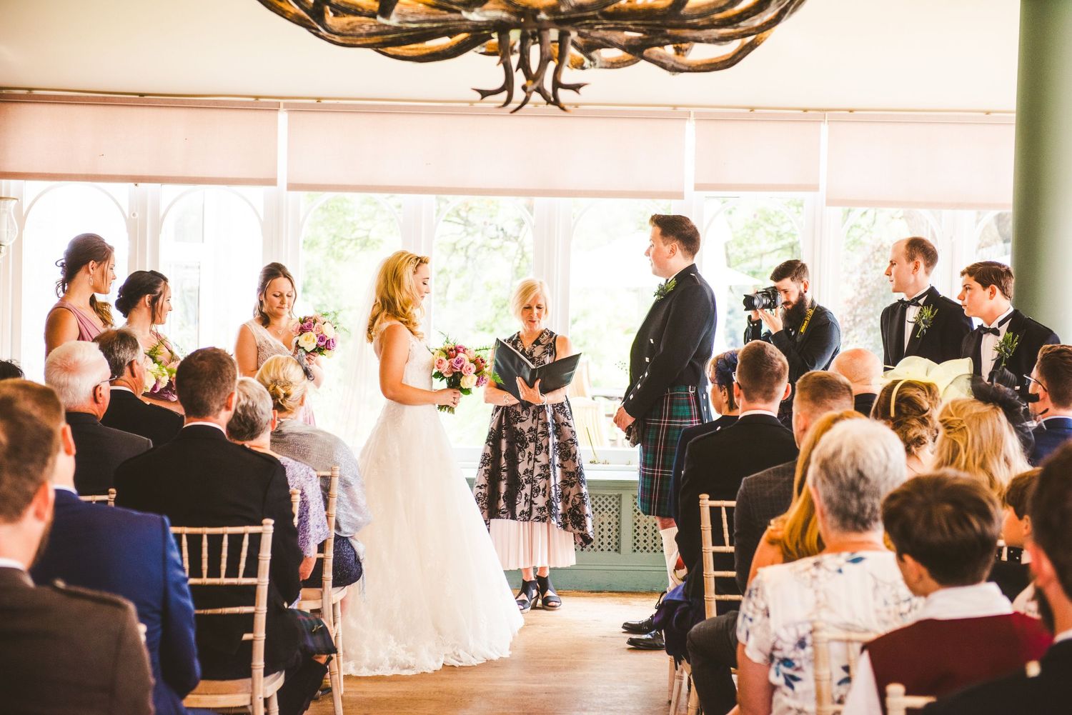 Wedding reception venue with elegant chandelier and chiavari chairs.