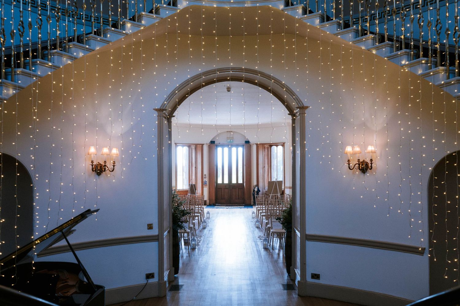 Elegant wedding venue interior with cascading fairy lights and white decor creating a magical ambiance.