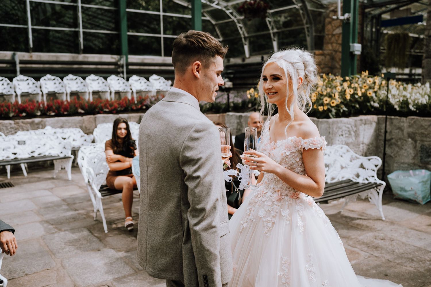 Newlyweds share their first moments together in a glass-enclosed wedding venue.