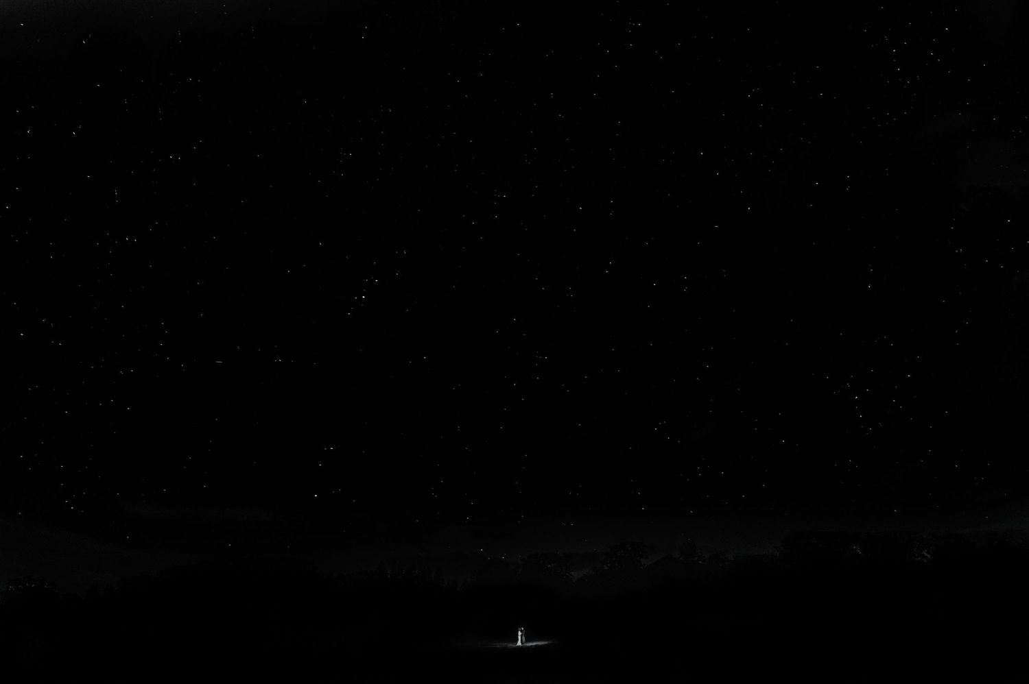 A dark nighttime scene with distant lights glowing in the darkness.