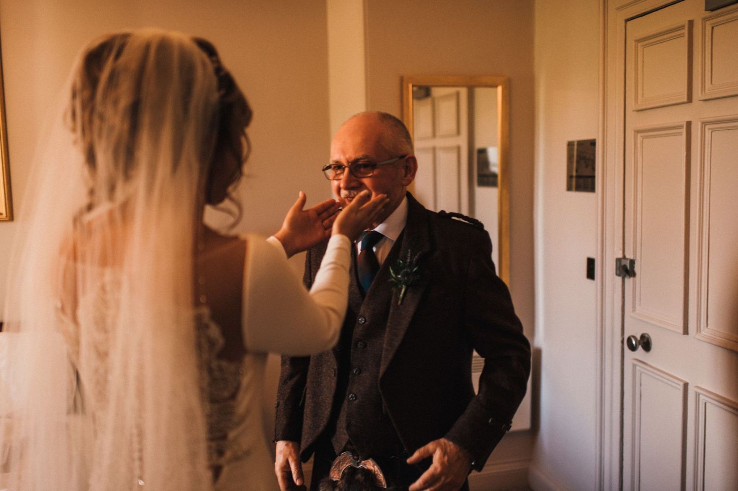Emotional wedding day reaction in sunlit room.