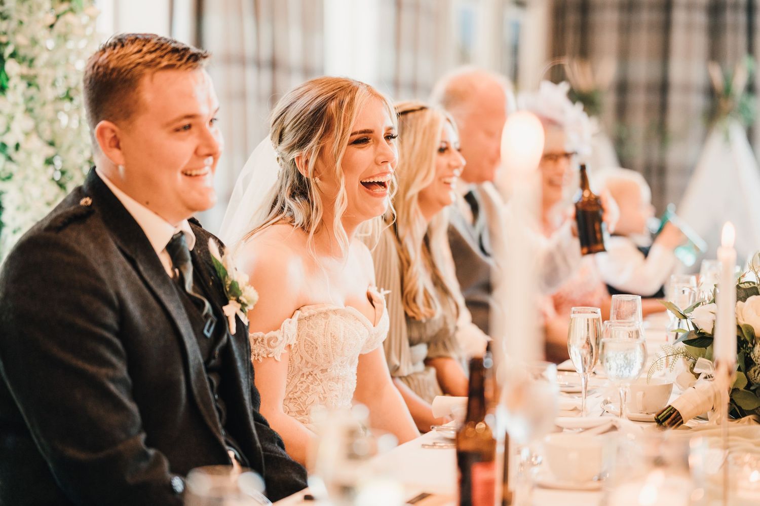 Wedding guests enjoying a formal reception dinner in a beautifully decorated venue.