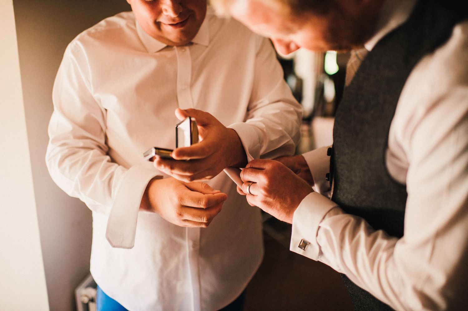 Close-up shot of hands preparing wedding rings before ceremony.