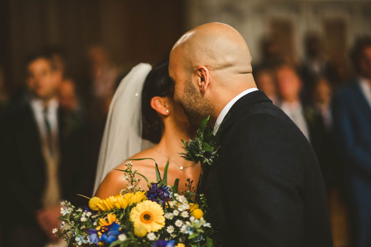 Intimate moment during wedding ceremony with yellow flower bouquet.