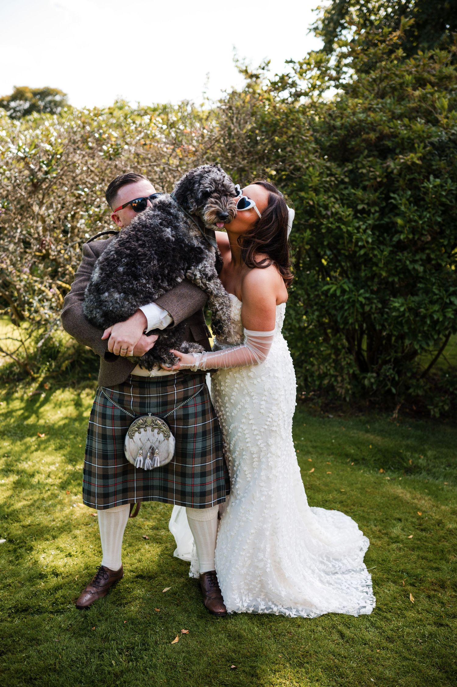 Aberdeen Wedding Photography. Scottish wedding attire with traditional kilts and white dress photographed in a garden setting.