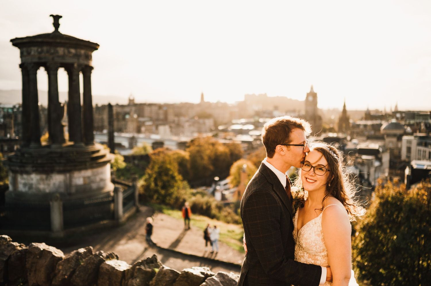 Aberdeen Wedding Photography. A couple embraces on a scenic overlook with historic architecture and city views in the background.