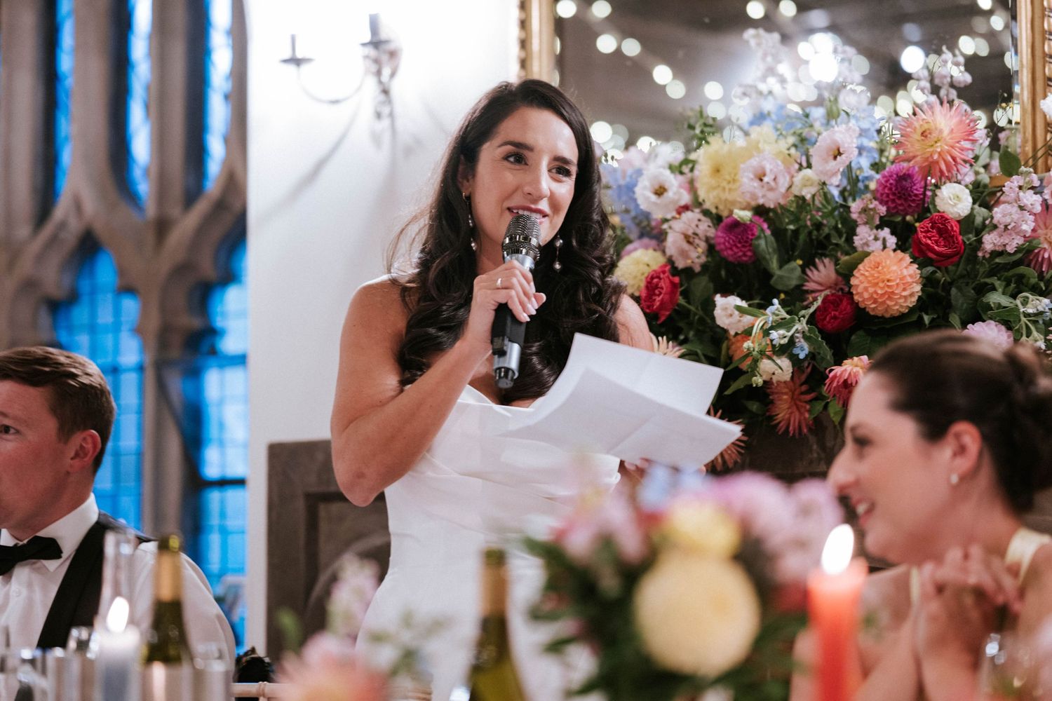 Elegant wedding reception dinner with floral arrangements and candlelight.