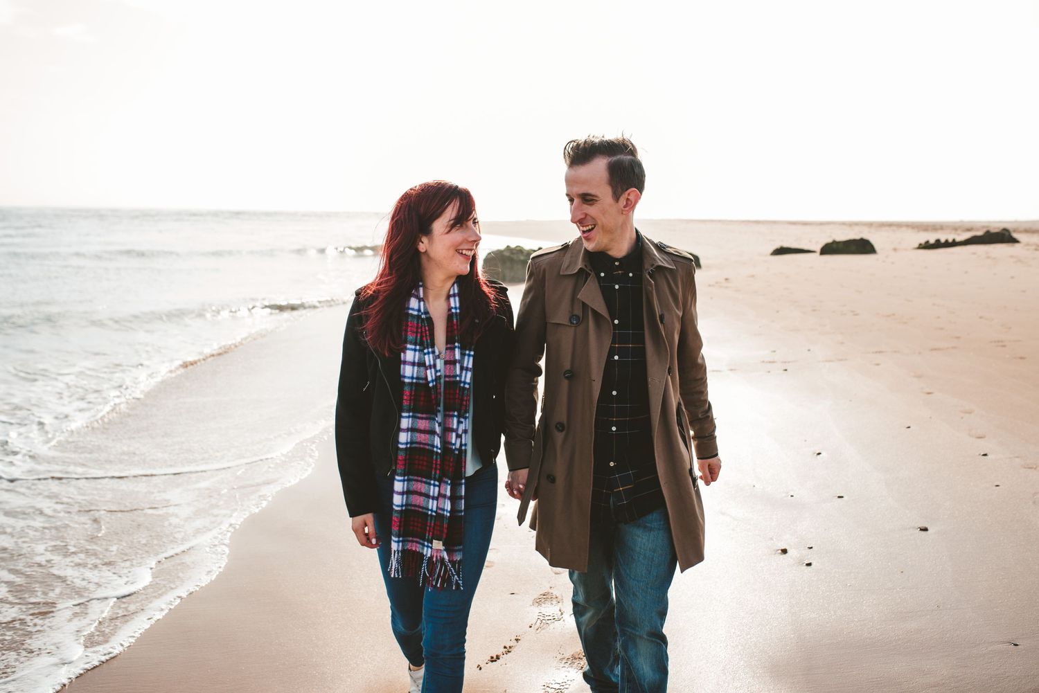 A couple taking a romantic walk along a beautiful beach shoreline.