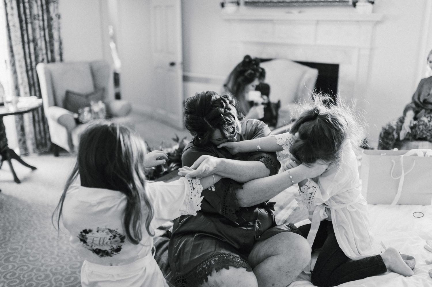 Black and white candid moment of playful interaction on bed.