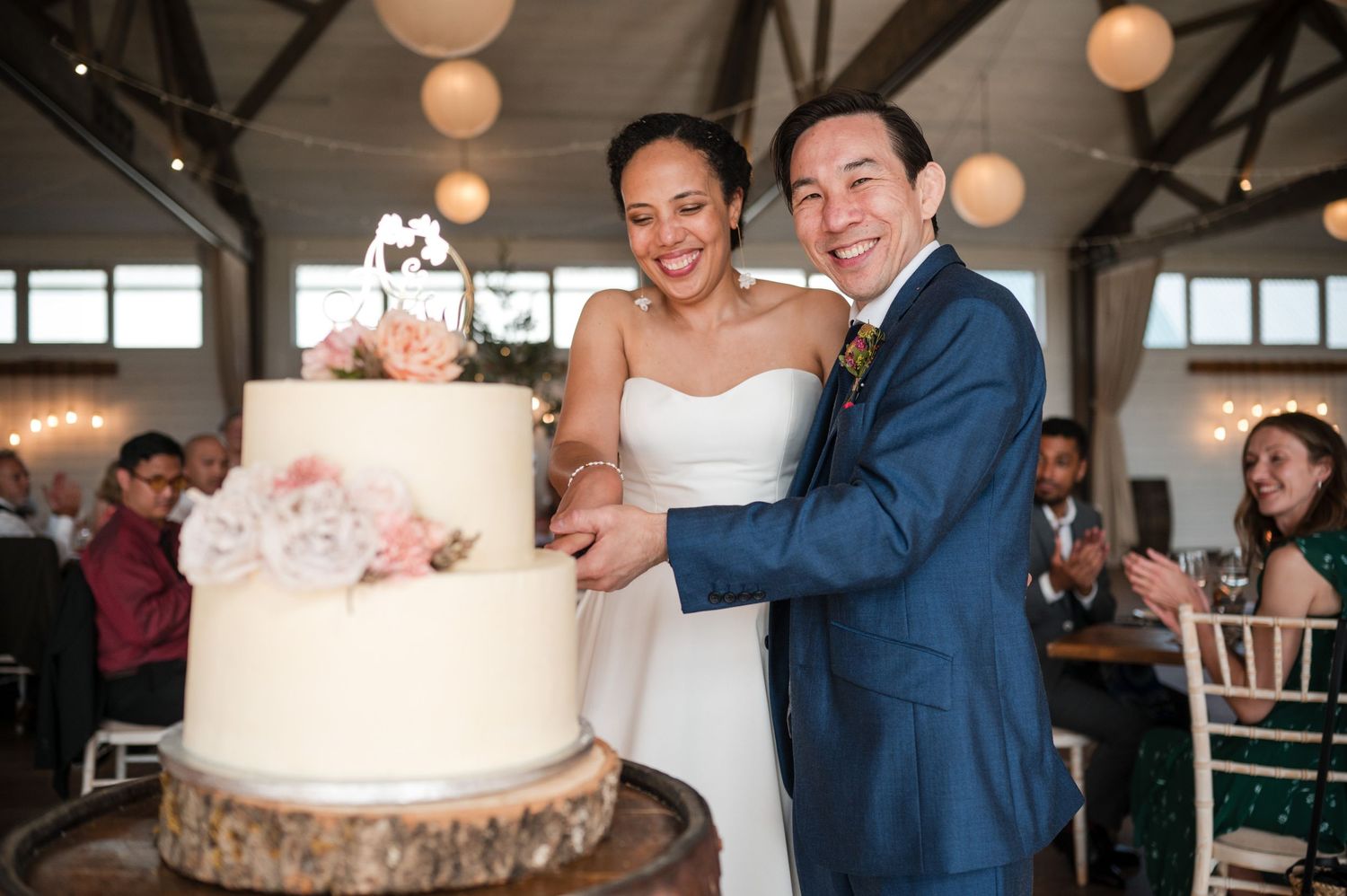 Wedding reception moments captured in a bright, airy venue with paper lantern decorations.