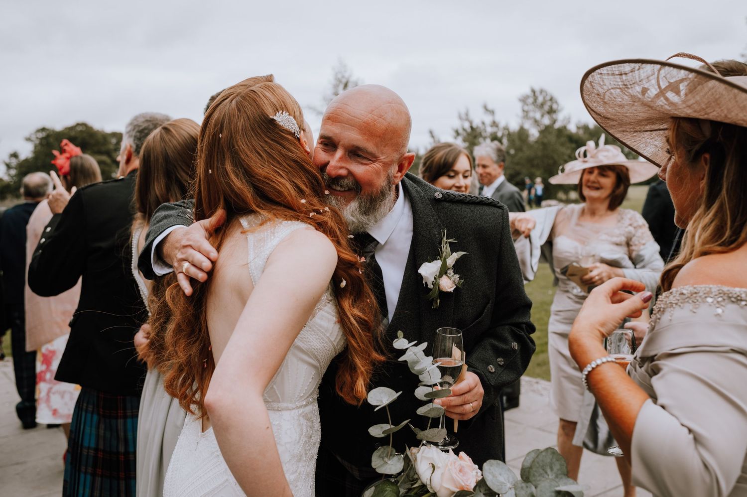 Wedding guests gather around during an outdoor celebration at a Scottish ceremony.