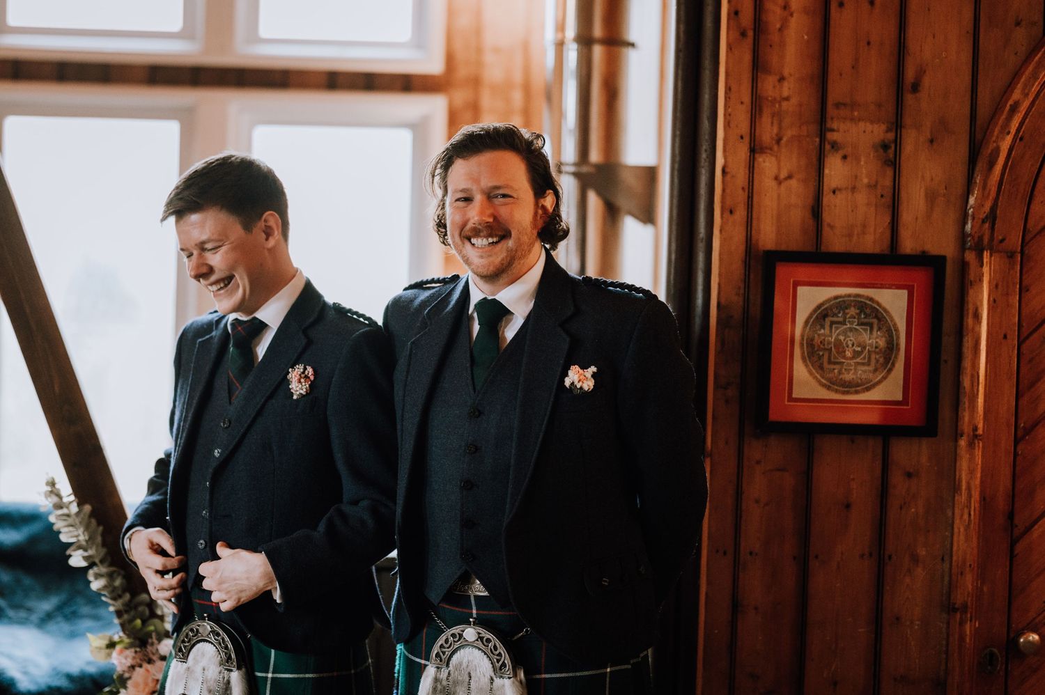 Two people in formal attire sharing a joyful moment in a wood-paneled room.