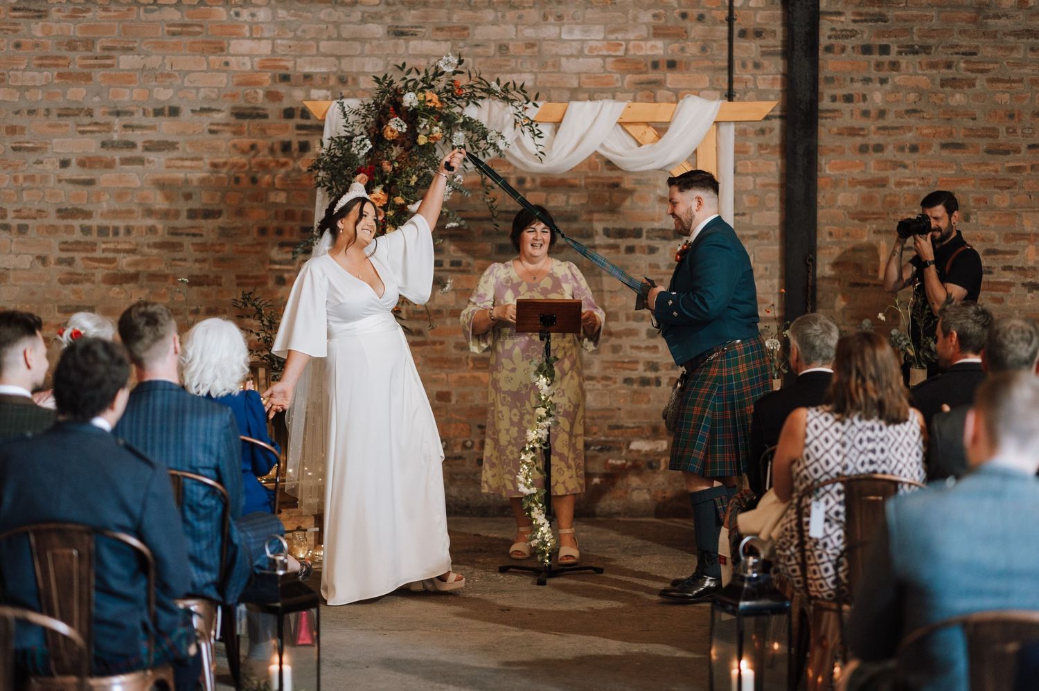 Wedding ceremony with Scottish traditions in industrial venue with exposed brick walls.