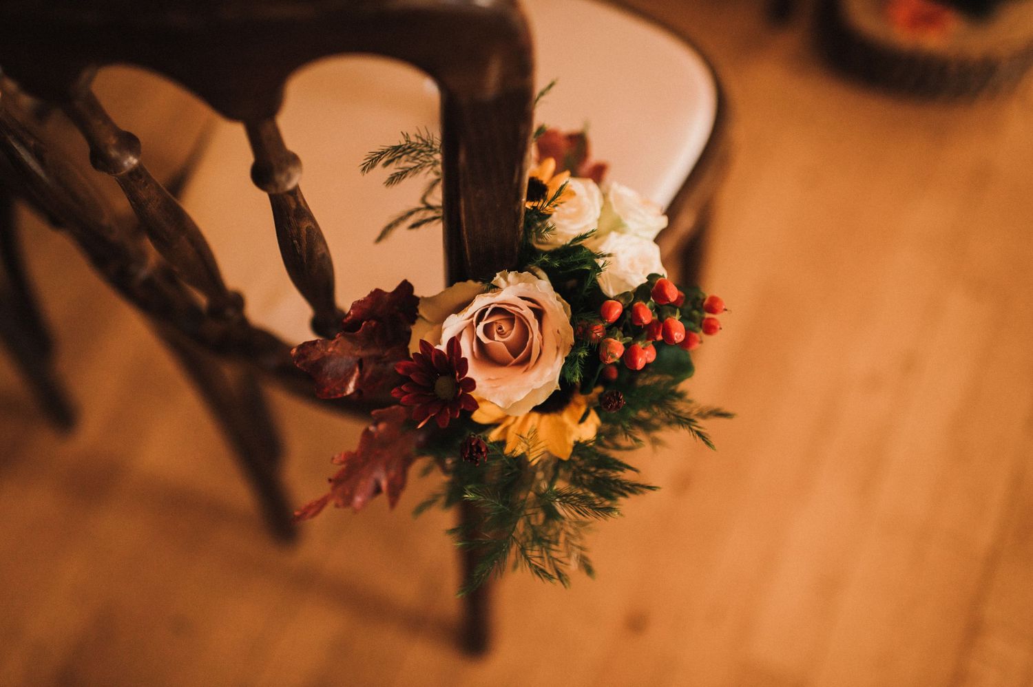 Romantic floral arrangement with burgundy and blush flowers on wooden surface.