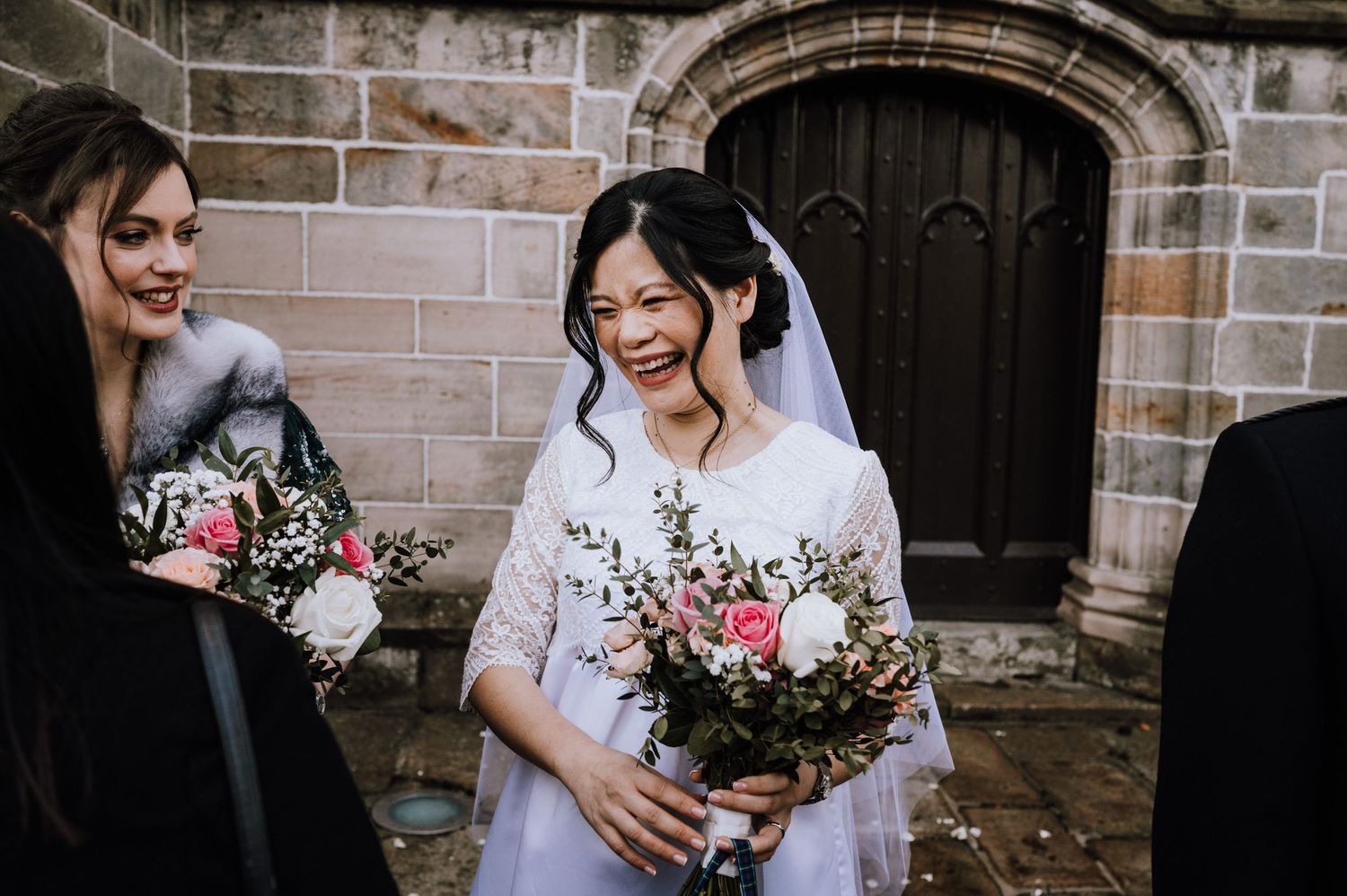 Joyful moments shared during a winter wedding celebration outside a stone church.
