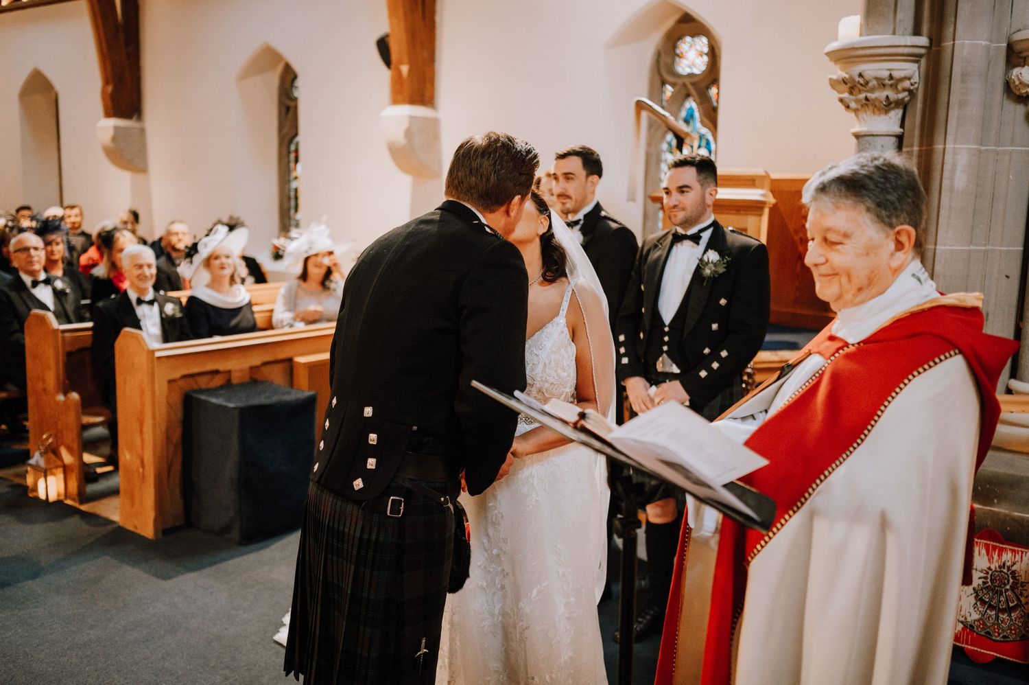 A traditional church wedding ceremony with Scottish elements and holiday decor.