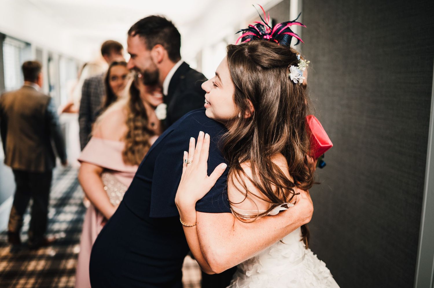 An emotional moment captured during a wedding celebration in a hallway.