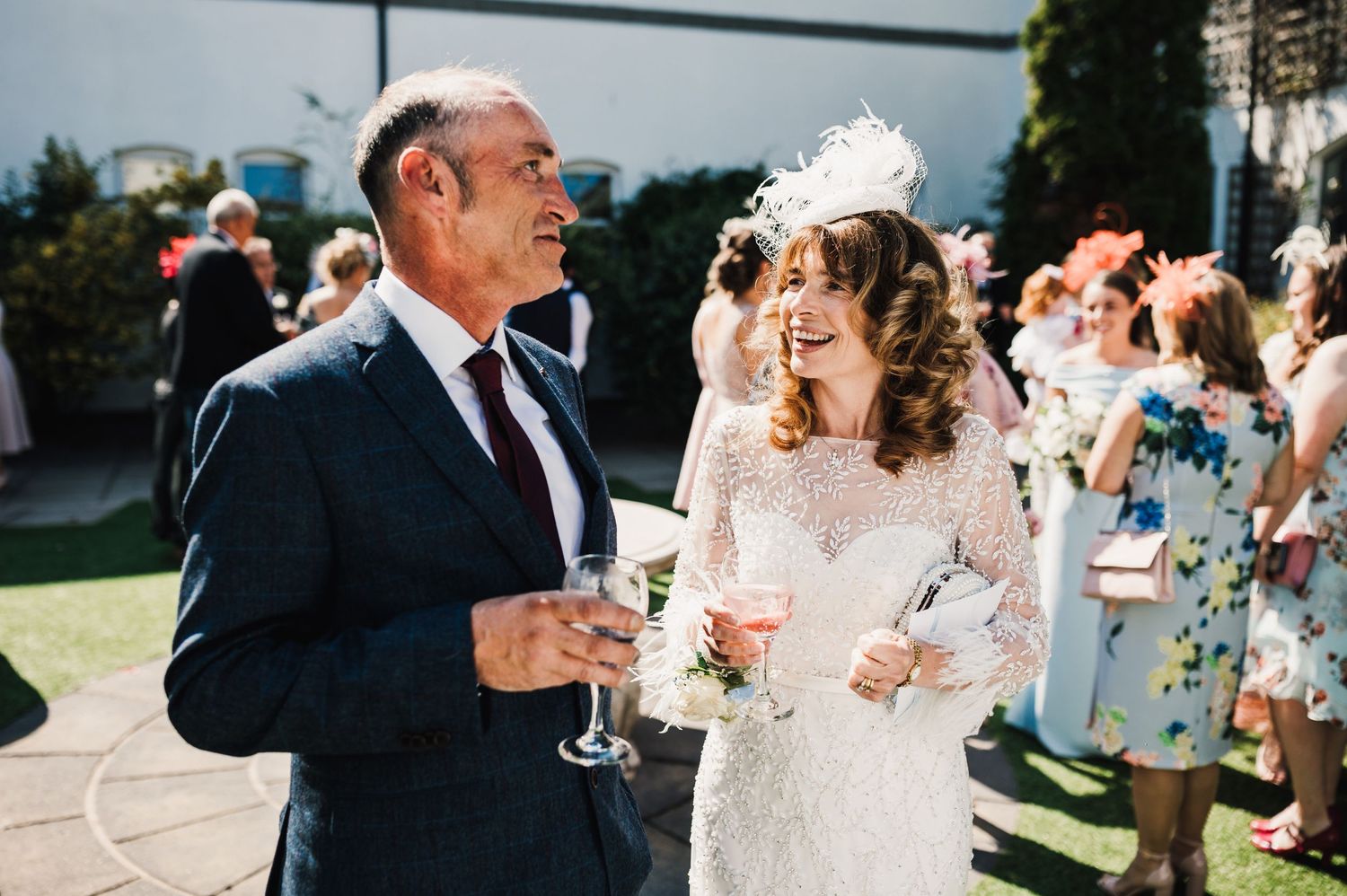 Wedding celebration moment with guests enjoying champagne on a sunny outdoor patio.