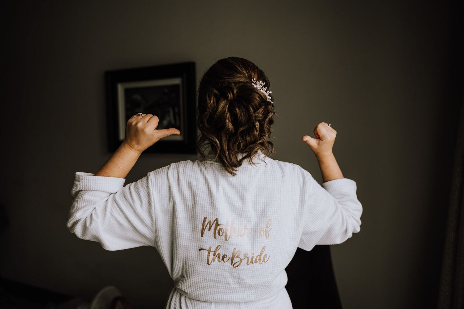 Wedding party members wearing white robes with gold text during preparations. Meldrum House Wedding Photography.