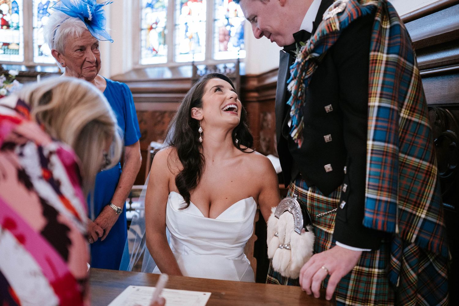 Wedding celebration with guests in formal attire inside an ornate church setting.