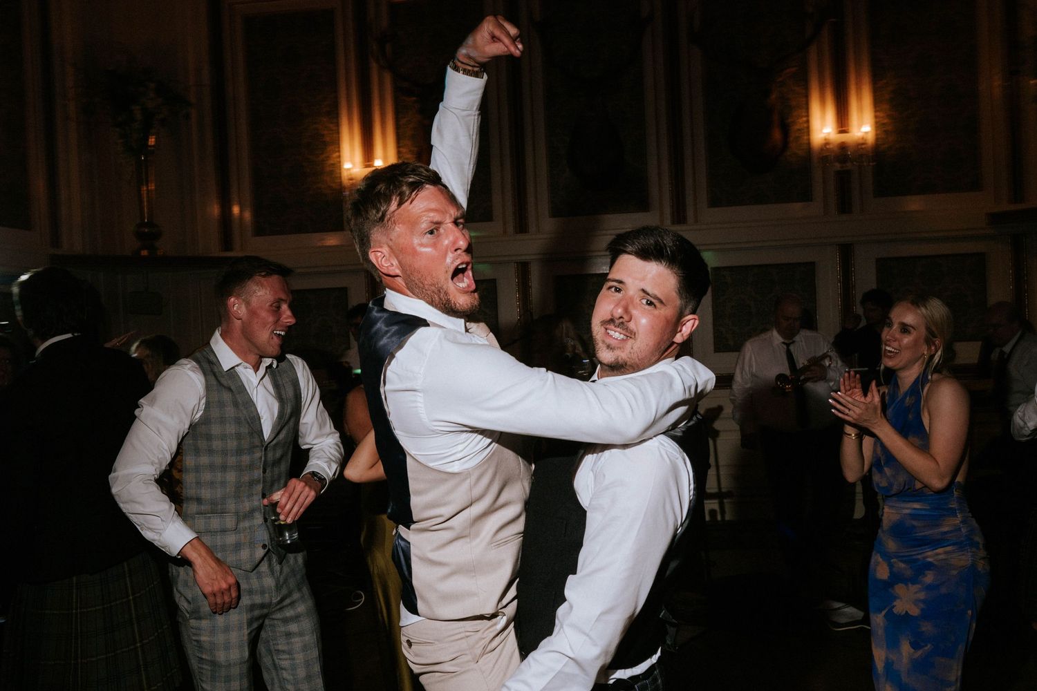 Wedding guests dance and celebrate during evening reception.