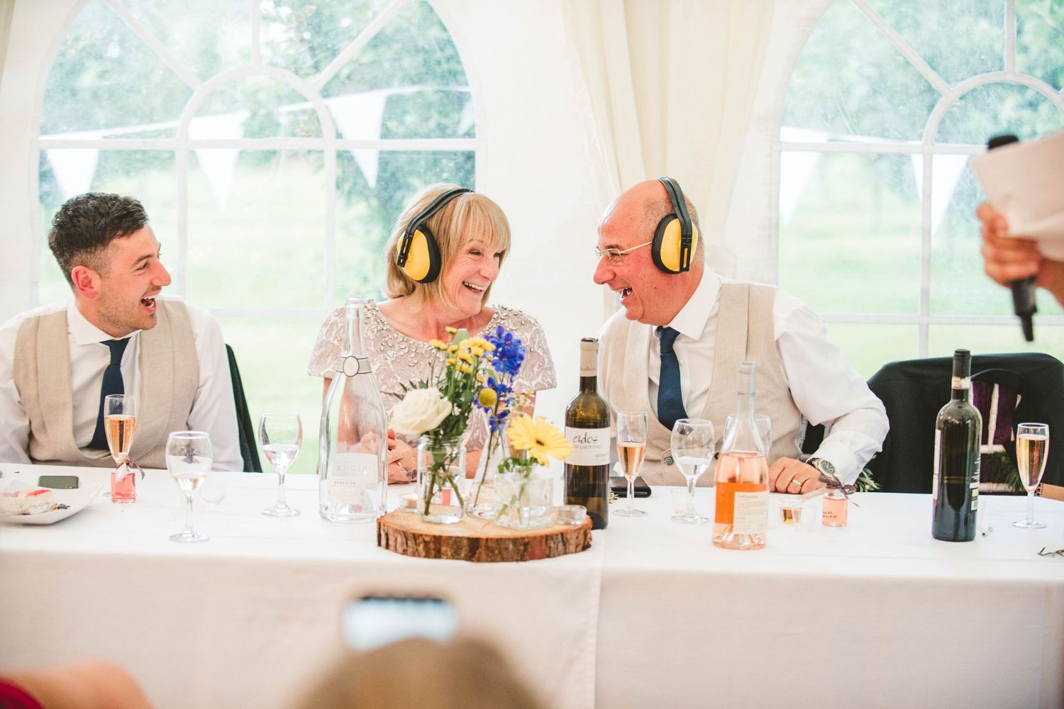 Wedding guests wearing yellow headphones during reception dinner.