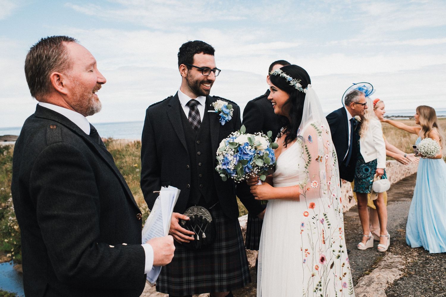 Wedding ceremony in progress on scenic coastal overlook.